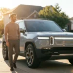 A man standing confidently by his car in a sunny driveway, symbolizing smart financial decisions.
