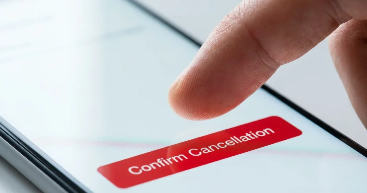 Finger tapping a red confirm cancellation button on a white mobile phone screen