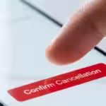 Finger tapping a red confirm cancellation button on a white mobile phone screen